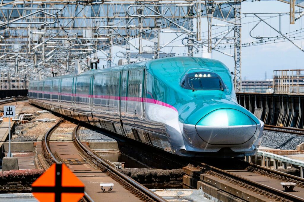 E5 Series Tohoku Shinkansen traveling through Aomori with its iconic green and pink design
