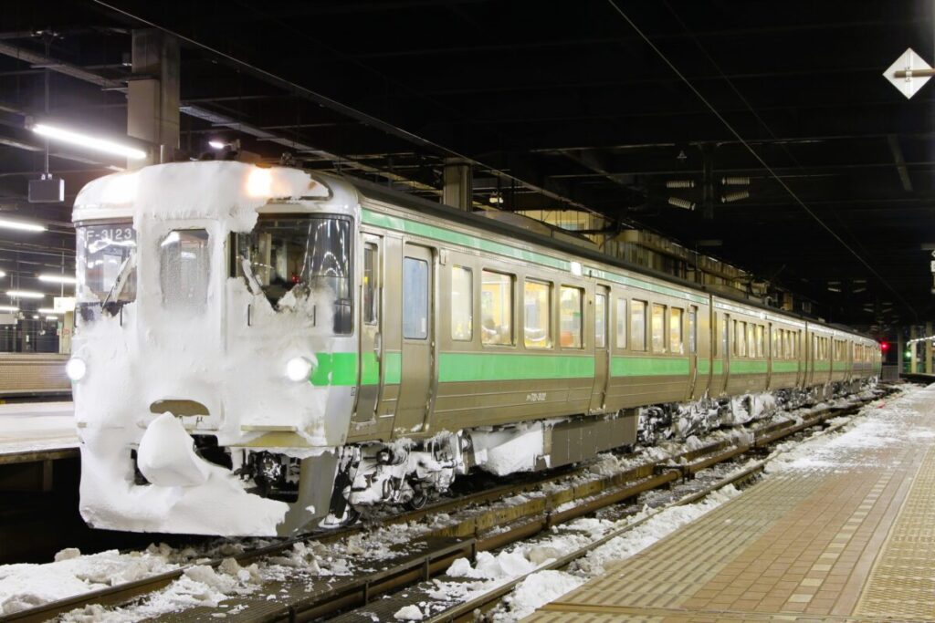 JR Hokkaido Rapid Airport train running through snowy winter landscape