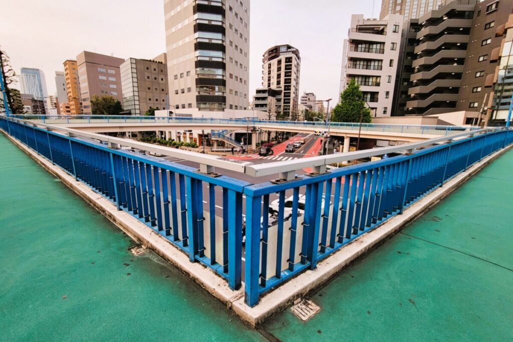 Pedestrian overpass in Shibuya with busy streets and city traffic below
