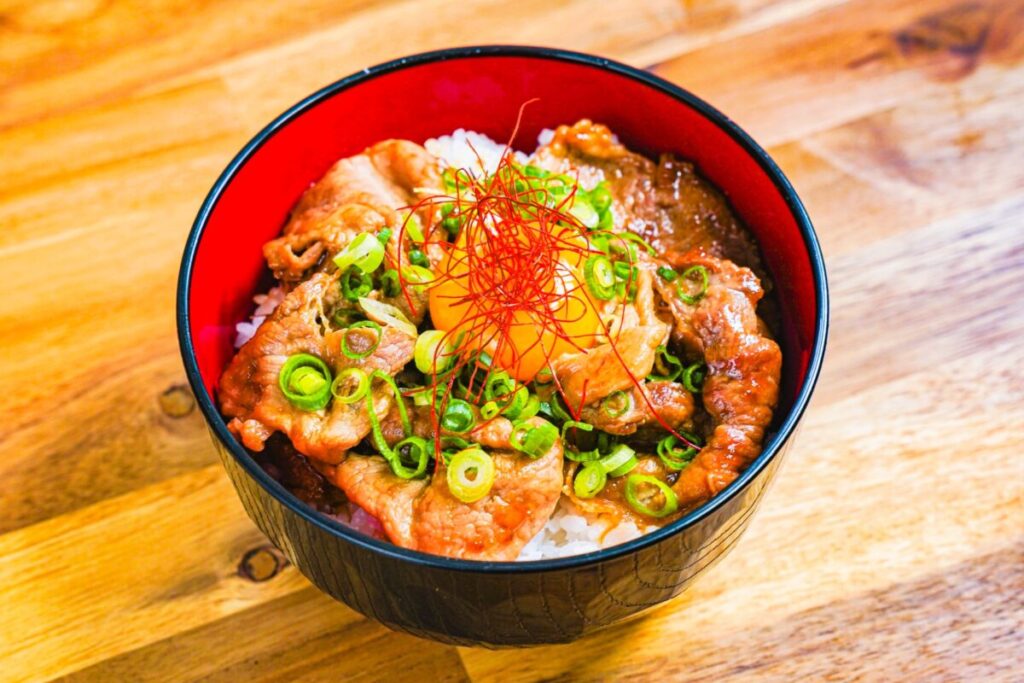Japanese pork rice bowl topped with raw egg yolk and sauce