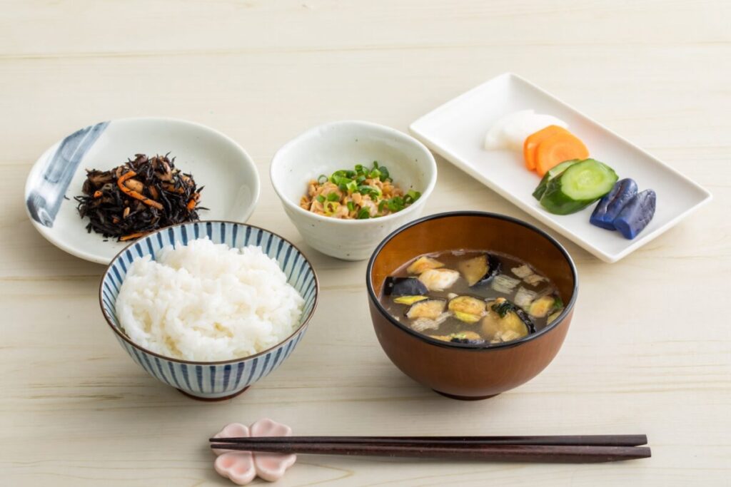 Traditional Japanese breakfast with rice, natto, miso soup, and side dishes