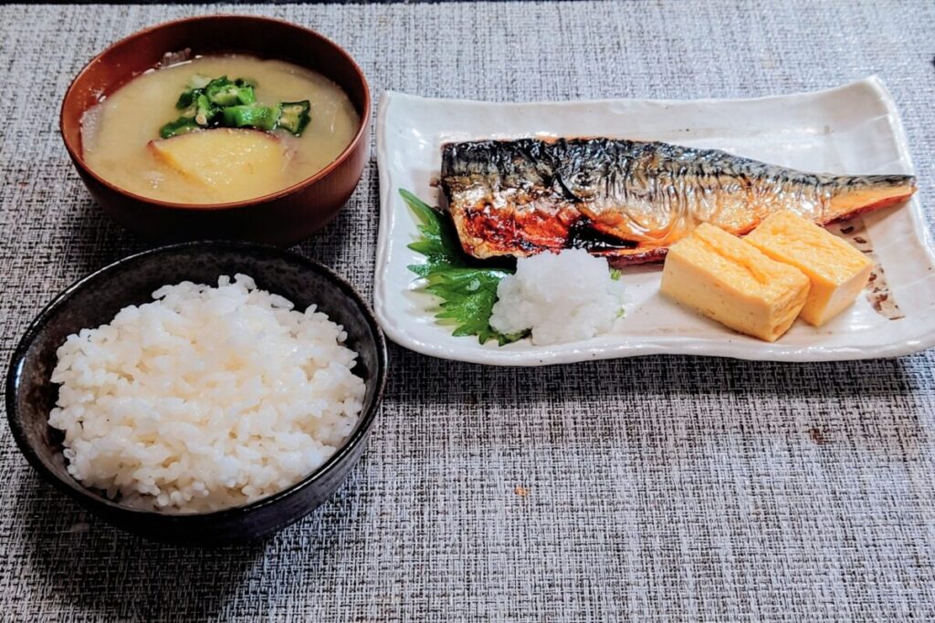Traditional Japanese breakfast with rice, miso soup, and grilled fish