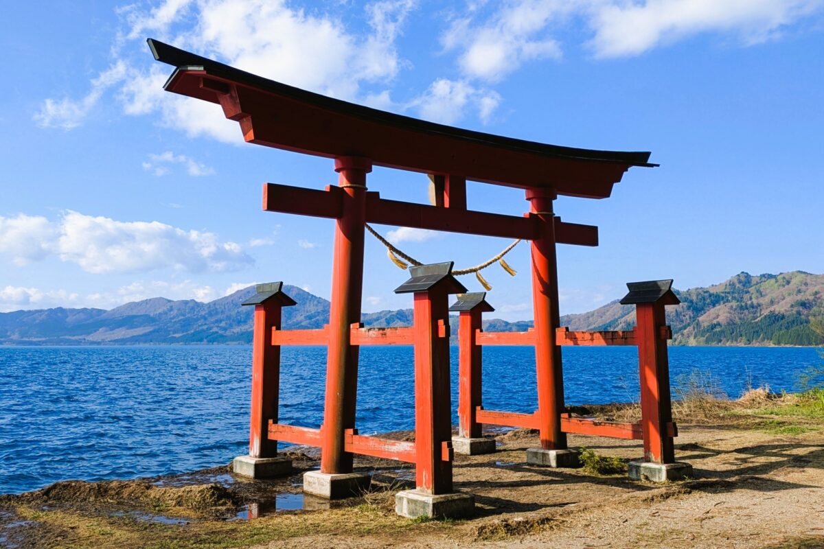 Gozaishi Shrine by Lake Tazawa in Akita Japan, scenic torii gate and lakeside shrine