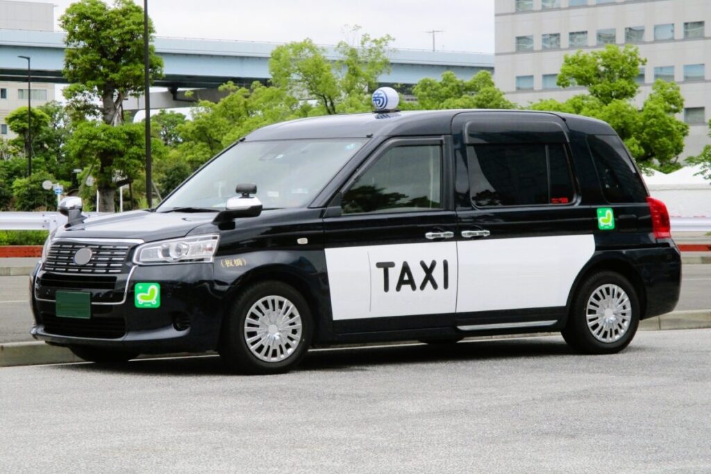 Japanese taxi driving through a city street in Japan, convenient urban transportation